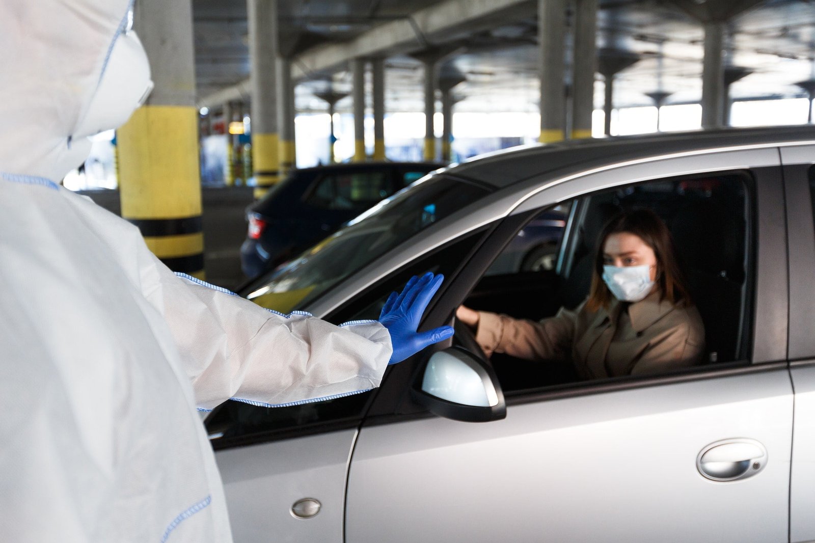 Man gesturing stop to woman in car warning of threat